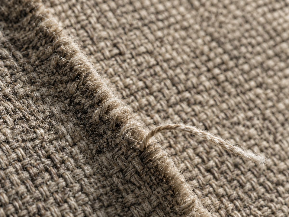 Détail d'un tissu : armure, lisière et fil tiré